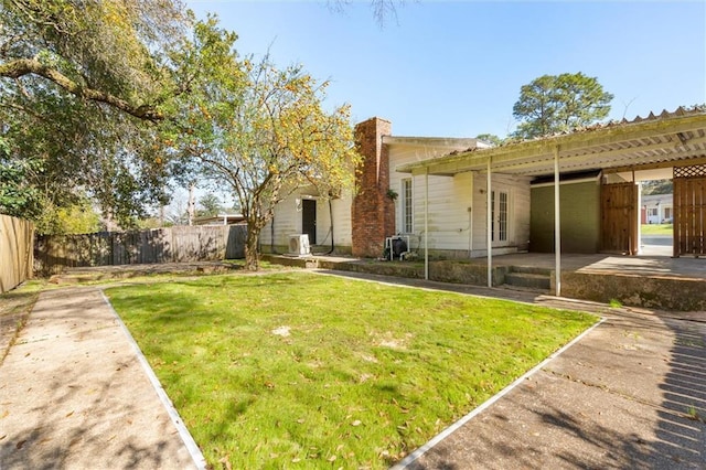 view of yard with a patio area, an attached carport, and fence