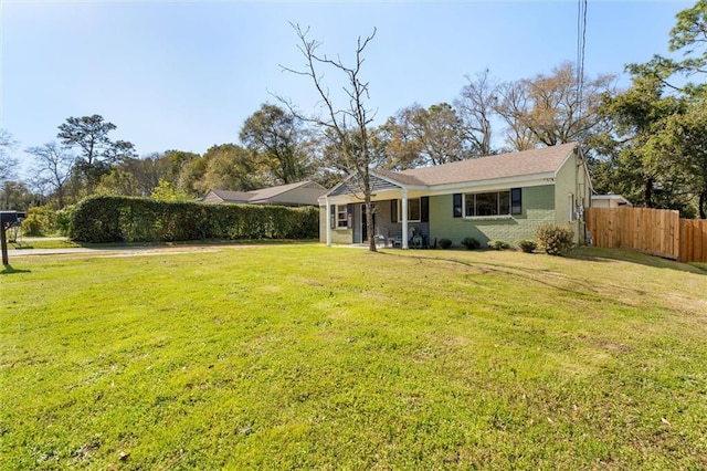 ranch-style home with brick siding, a front lawn, and fence