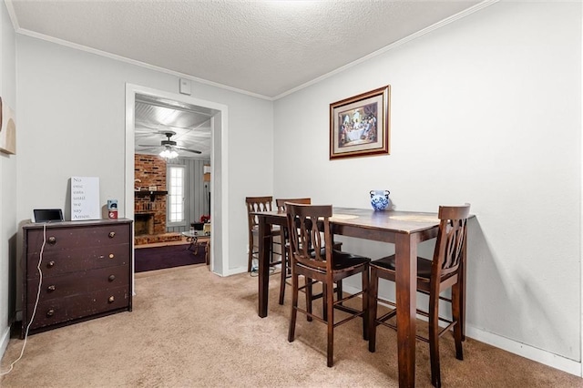 carpeted dining area with crown molding, a ceiling fan, baseboards, and a textured ceiling