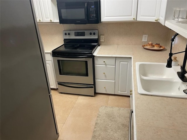 kitchen featuring light countertops, appliances with stainless steel finishes, a sink, and white cabinets