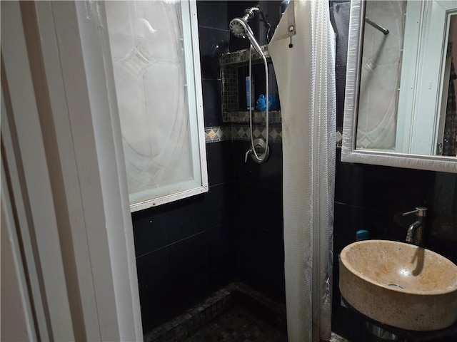 bathroom featuring a sink and a tile shower