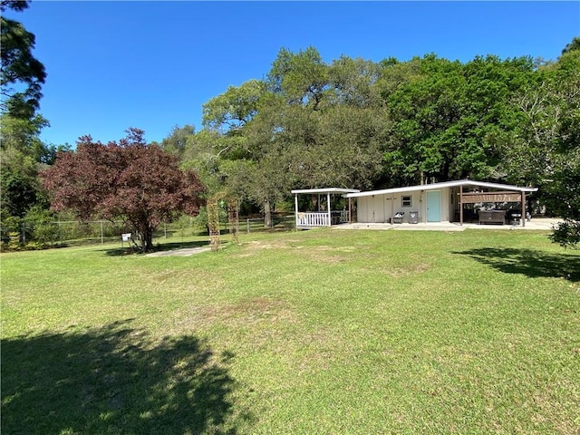 view of yard featuring fence and a carport