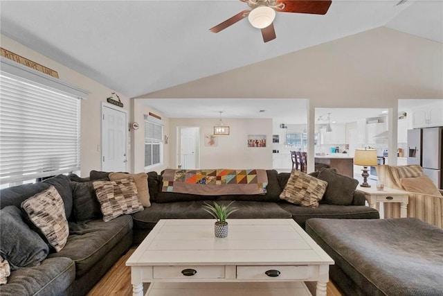 living area with ceiling fan and lofted ceiling