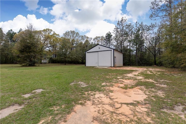 view of yard with a pole building, a detached garage, an outbuilding, and dirt driveway