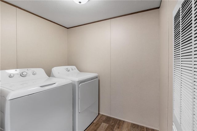 washroom with washing machine and dryer, wood finished floors, crown molding, and laundry area