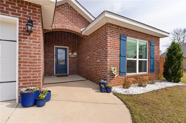 property entrance with a garage and brick siding