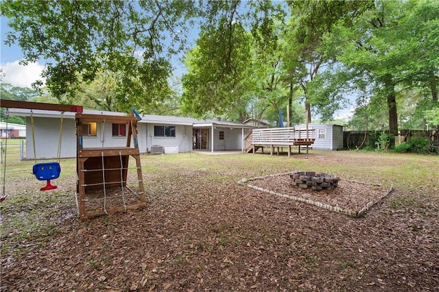 4359 Montclair Cir E, Mobile, AL 36693 - rear view of property with a fire pit, an outdoor structure, fence, a storage shed, and central AC