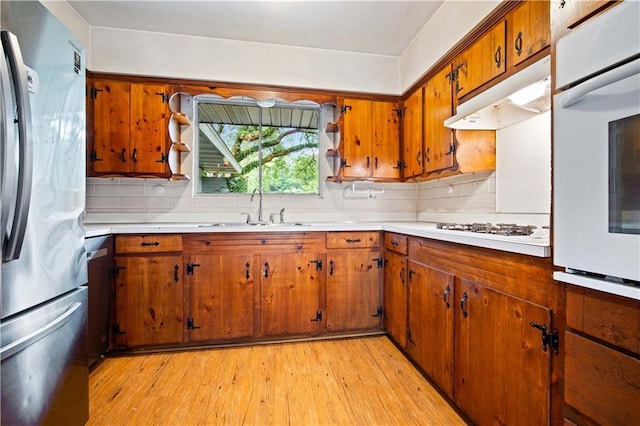 4359 Montclair Cir E, Mobile, AL 36693 - kitchen with white appliances, a sink, brown cabinetry, and light countertops