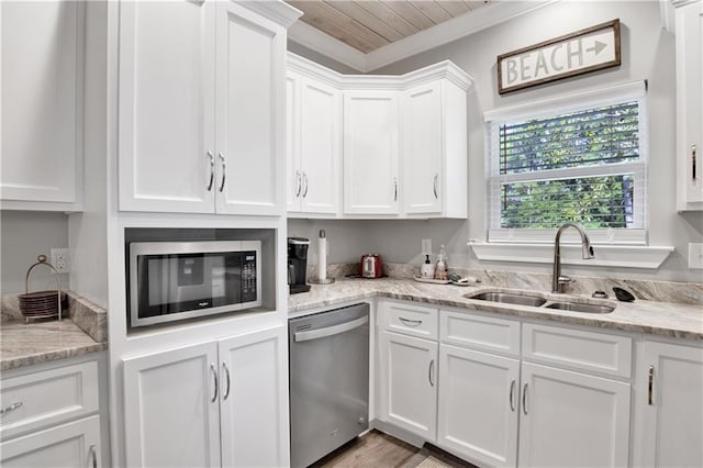 kitchen featuring light stone countertops, white cabinetry, sink, crown molding, and appliances with stainless steel finishes