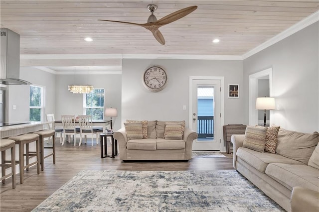 living room with wood-type flooring, ceiling fan with notable chandelier, ornamental molding, and wooden ceiling