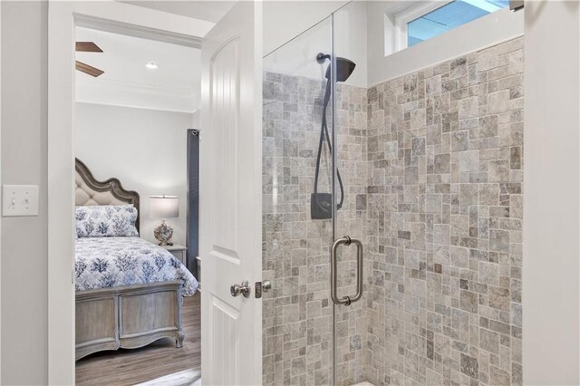 bathroom featuring hardwood / wood-style floors, ceiling fan, and an enclosed shower