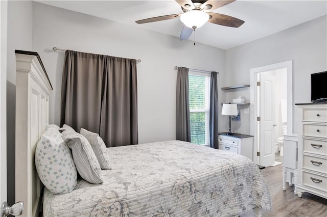 bedroom with light wood-type flooring, ensuite bathroom, and ceiling fan