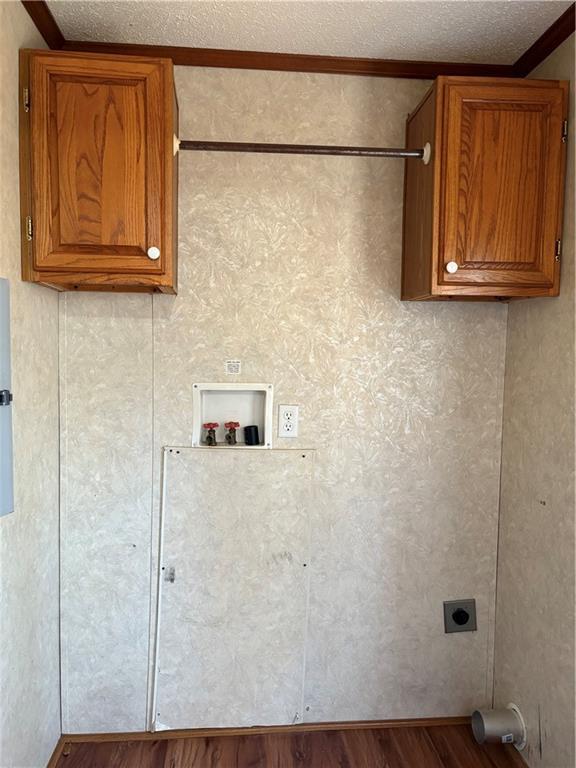 laundry room featuring light wood-type flooring, cabinets, hookup for a washing machine, hookup for an electric dryer, and a textured ceiling