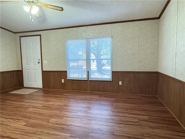 spare room featuring ornamental molding, hardwood / wood-style floors, ceiling fan, and a textured ceiling