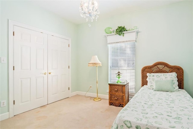 carpeted bedroom with a chandelier and a closet