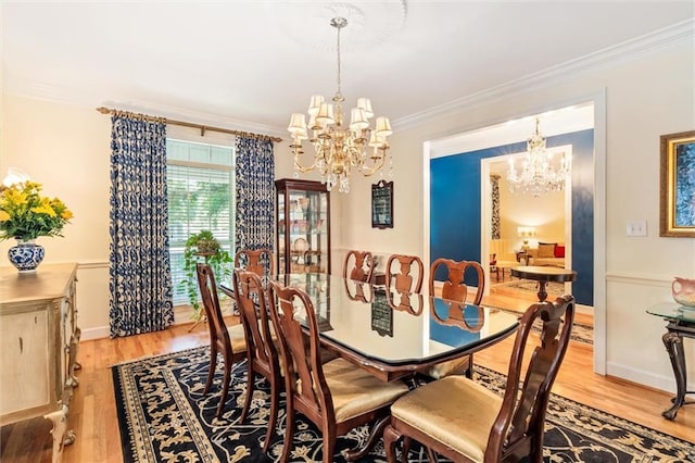 dining area featuring a chandelier, light hardwood / wood-style floors, and crown molding