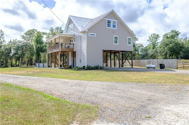 view of front of property featuring a front yard, a carport, and a balcony