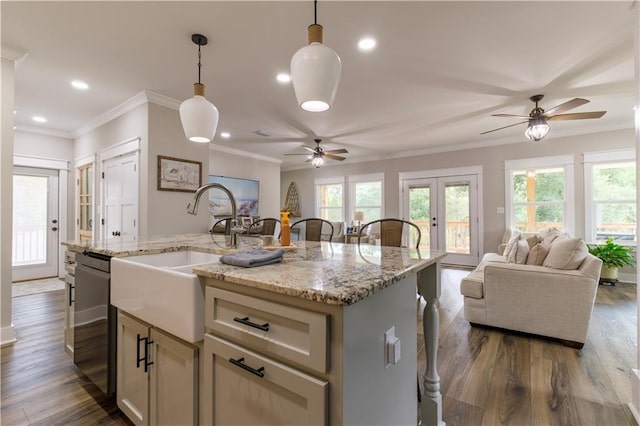 kitchen featuring pendant lighting, a breakfast bar, a kitchen island with sink, dark hardwood / wood-style flooring, and dishwasher