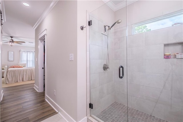 bathroom with a shower with door, a wealth of natural light, hardwood / wood-style floors, and crown molding