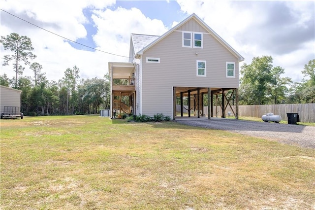 back of property featuring a carport and a lawn