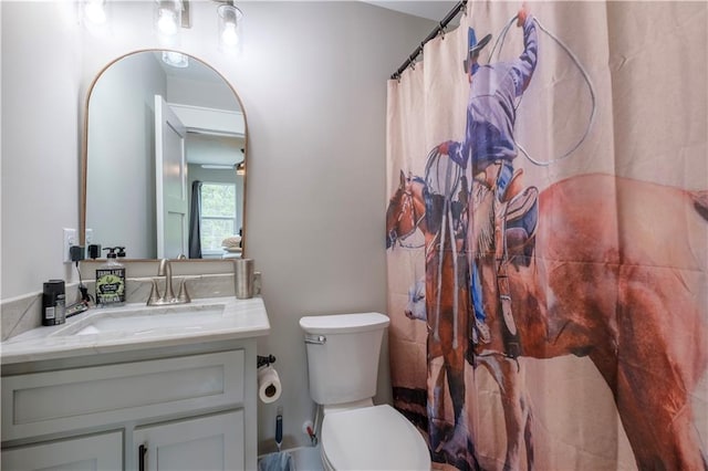 bathroom with curtained shower, ceiling fan, vanity, and toilet