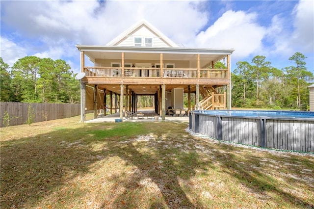 back of house featuring a patio area, a swimming pool side deck, and a yard