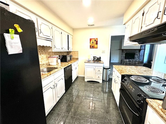 kitchen with tasteful backsplash, white cabinets, black appliances, and light stone counters