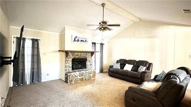 living room featuring lofted ceiling with beams, ceiling fan, a stone fireplace, crown molding, and carpet flooring