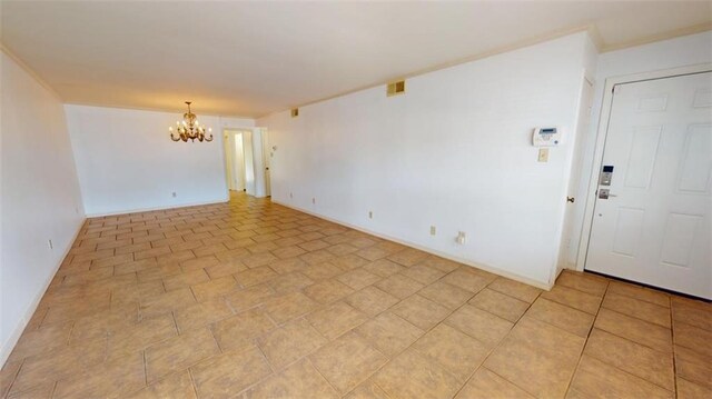 spare room featuring an inviting chandelier