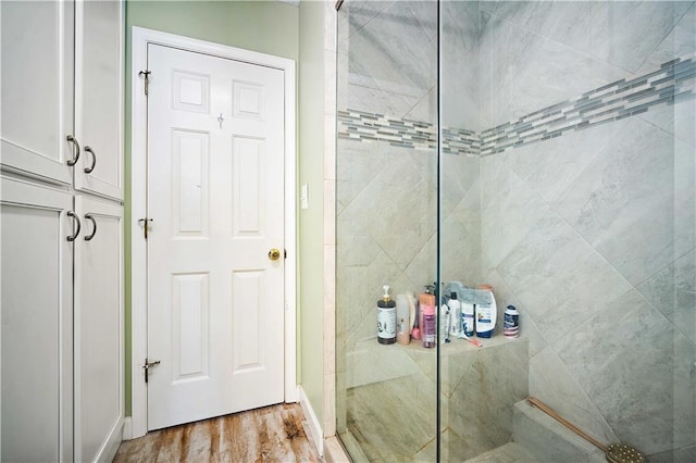 bathroom featuring wood-type flooring and a shower with door