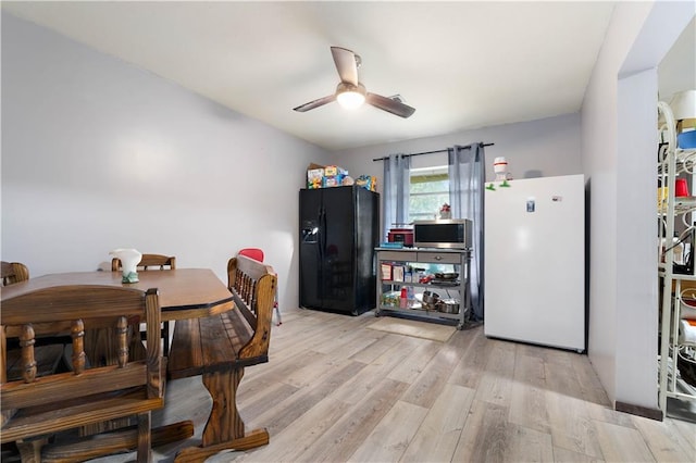 dining space featuring ceiling fan and light wood-type flooring