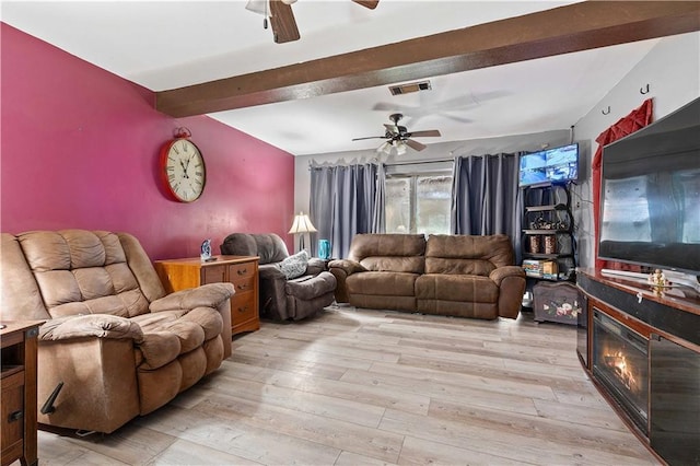 living room with ceiling fan, light wood-type flooring, and beam ceiling