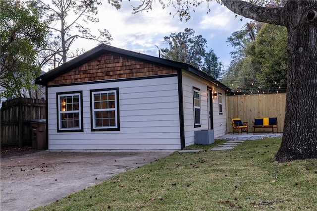 view of side of property with a yard, fence, central AC, and a patio