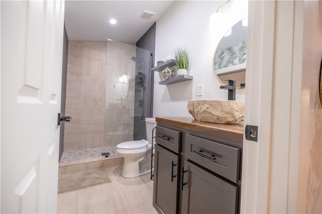 bathroom featuring visible vents, tile patterned floors, a walk in shower, and vanity