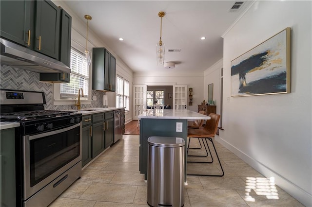 kitchen with visible vents, a sink, appliances with stainless steel finishes, under cabinet range hood, and backsplash