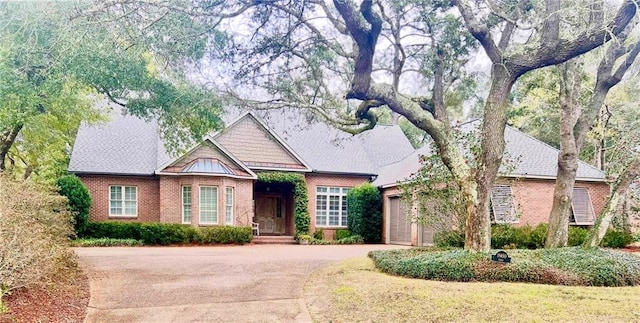 view of front facade with a garage, driveway, and brick siding