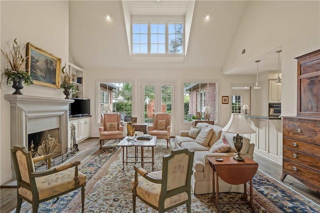 living area with dark wood-style floors, visible vents, a fireplace, and high vaulted ceiling