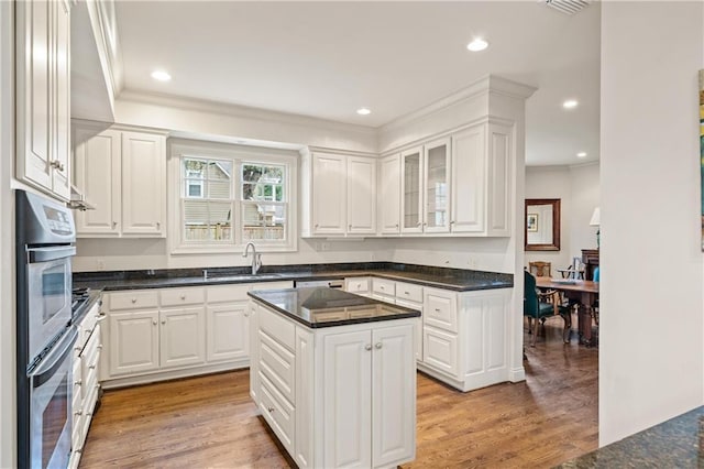 kitchen featuring dark countertops, a center island, and white cabinets