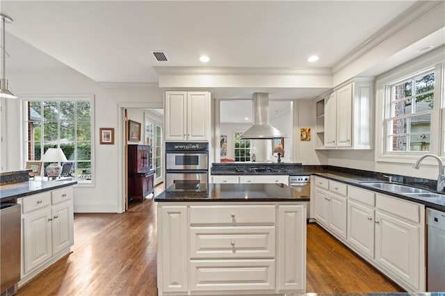 kitchen featuring appliances with stainless steel finishes, white cabinets, island exhaust hood, and a sink