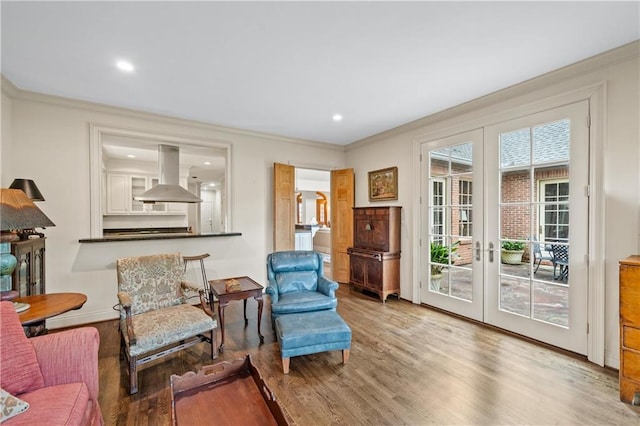 sitting room featuring baseboards, ornamental molding, wood finished floors, french doors, and recessed lighting