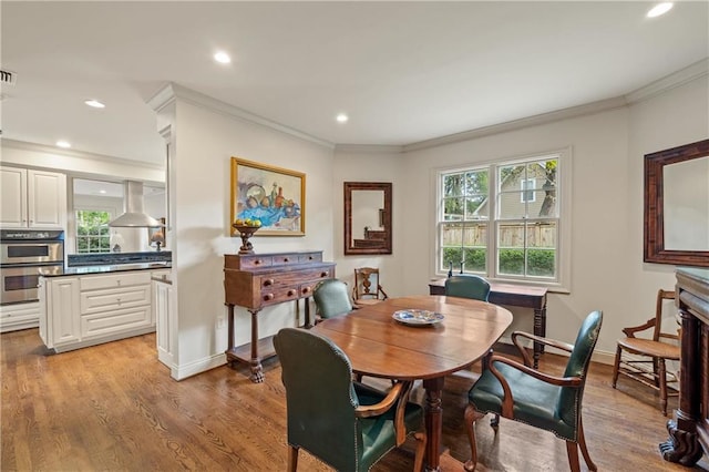 dining area with ornamental molding, plenty of natural light, and light wood-style flooring