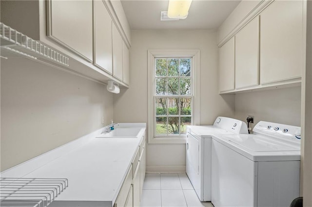 laundry room featuring washing machine and dryer, a healthy amount of sunlight, cabinet space, and a sink