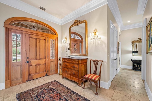 foyer entrance with ornamental molding, visible vents, and baseboards