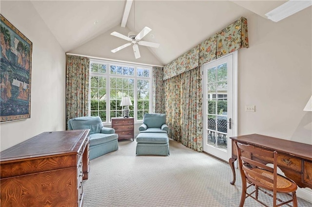 living area with vaulted ceiling with beams, a ceiling fan, and light colored carpet