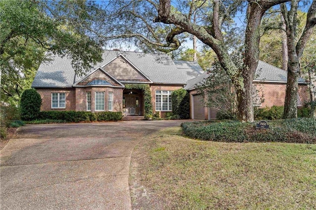 view of front of home featuring brick siding, driveway, and an attached garage