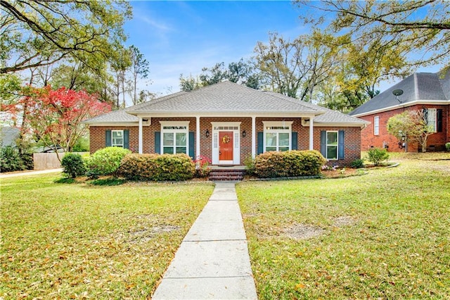 view of front facade featuring brick siding, covered porch, and a front lawn