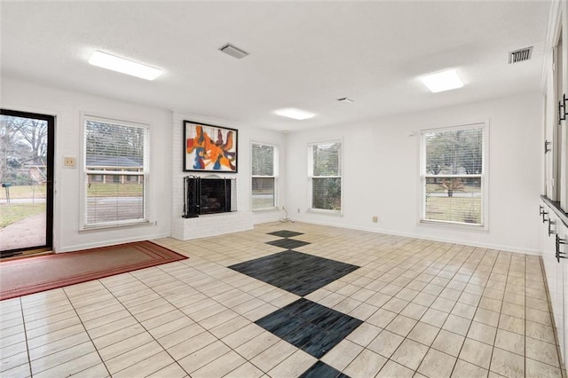 unfurnished living room featuring light tile patterned floors, baseboards, a fireplace, and visible vents