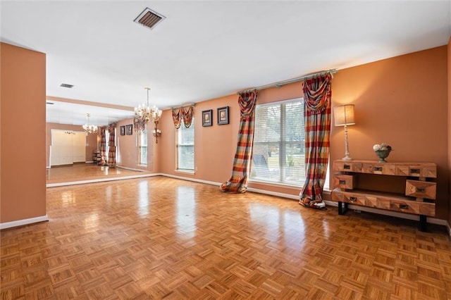 interior space with a chandelier, visible vents, and baseboards