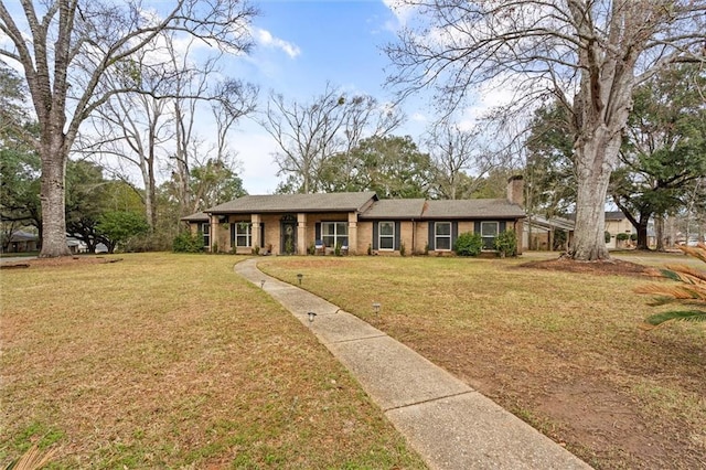 ranch-style house with a front lawn, a chimney, and brick siding