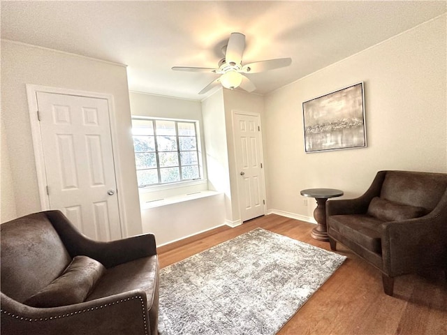 living area with hardwood / wood-style flooring and ceiling fan